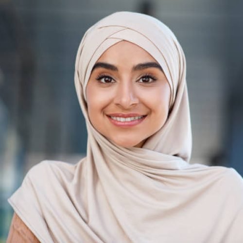 istockphoto-1342029049-612×612 Head shot of beautiful woman student, teacher or blogger. Portrait of smiling millennial beautiful nice middle eastern woman in hijab look at webcam, make video call outdoor, close up, free space